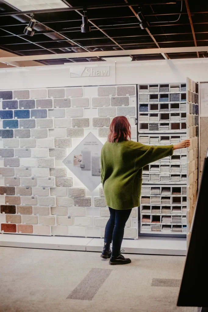 Flooring professional looking at a wall of carpet samples